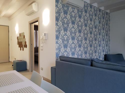 un soggiorno con divano blu e parete di Sirmione Park View Luxury Apartments a Sirmione