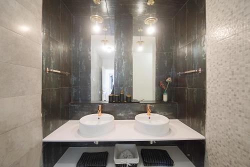 a bathroom with two sinks and a mirror at Lei Home in Cascais
