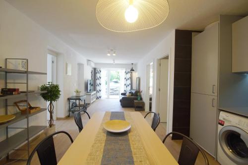 a dining room and living room with a table and a kitchen at Lei Home in Cascais