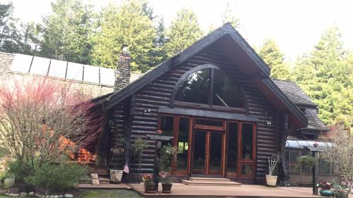 a log cabin with a large window and a building at Redwood forest in Crescent City