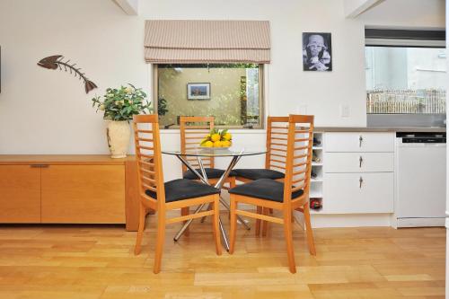 a kitchen with a glass table and chairs in a kitchen at Salisbury Apartment - Christchurch Holiday Homes in Christchurch