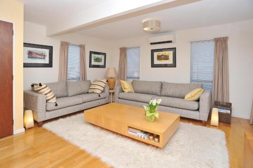 a living room with two couches and a coffee table at Salisbury Apartment - Christchurch Holiday Homes in Christchurch