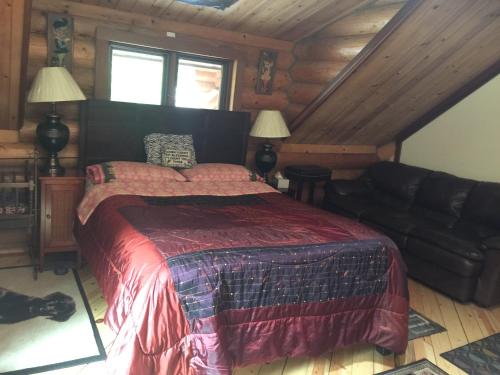 1 dormitorio con 1 cama y 1 sofá en una cabaña en Redwood forest en Crescent City