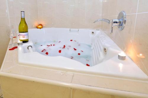una bañera blanca con una botella de vino. en Boathouse Resort (Water Front) en Tea Gardens