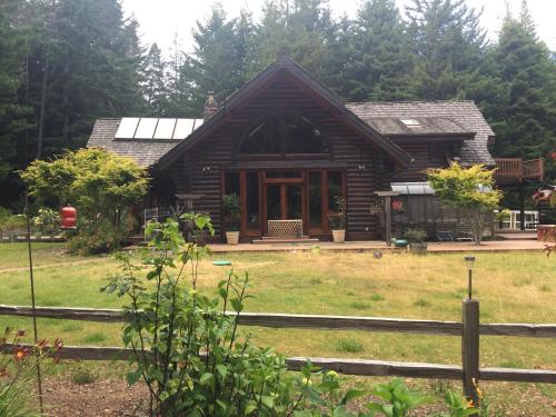 a log cabin with a fence in front of it at Redwood forest in Crescent City