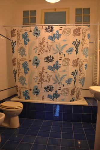 a bathroom with a shower curtain with a toilet at CASA CALI' in Senigallia
