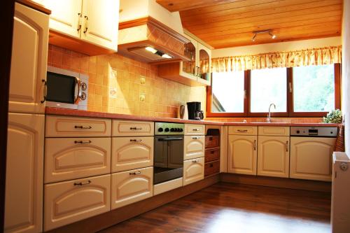 a kitchen with white cabinets and a sink at Apartments Landhaus Sonnheim in Lofer