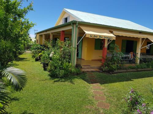 a yellow and red house with a yard at GITE-Hotel LA CAZ DES ORANGERS in Le Bois de Nèfles