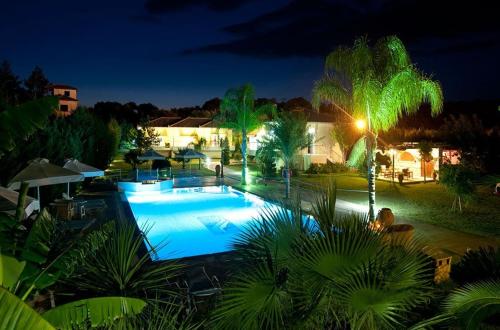 a large swimming pool at night with lights at Dion Zois in Finikounta