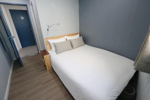 a small bedroom with a white bed in a room at HAH Guesthouse in Seoul