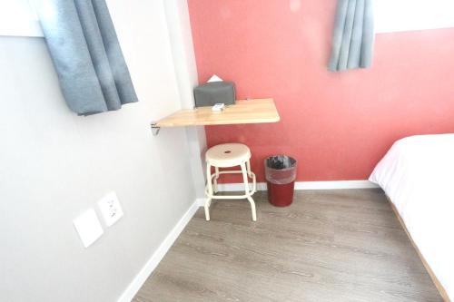 a small bedroom with a desk and a stool at HAH Guesthouse in Seoul