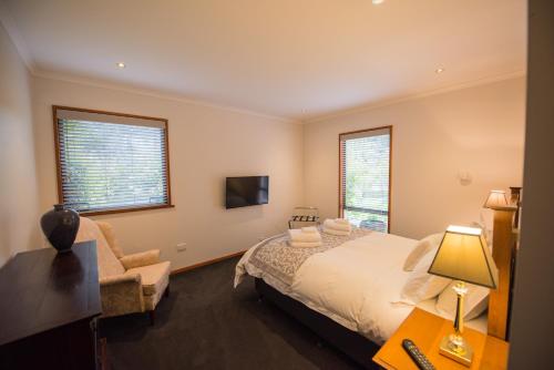 a bedroom with a bed and a chair and a television at Parnella Kettering in Kettering