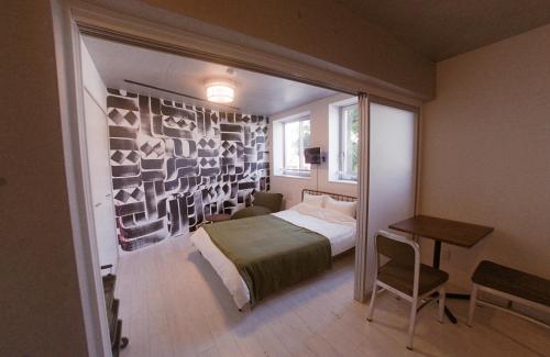 a bedroom with a bed and a desk in a room at AOCA KAMINOGE 201 in Tokyo