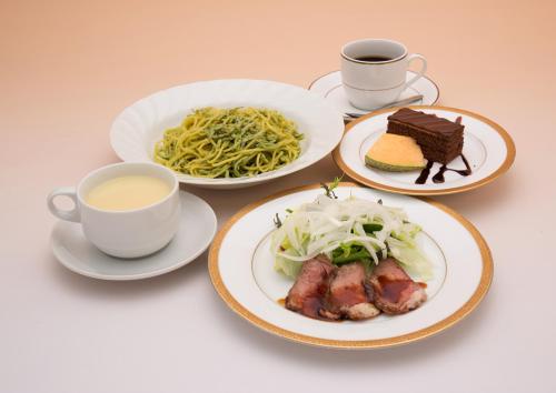 a table with plates of food and cups of coffee at Kur and Hotel Suruga in Shizuoka