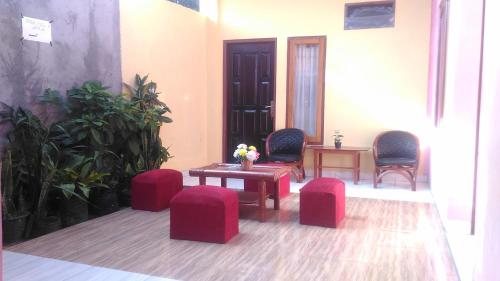 a room with red stools and a table and chairs at Hotel Edelweis 2 Bajawa in Bajawa