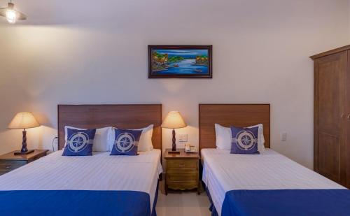 a hotel room with two beds with blue pillows at Santa Sea Villa in Hoi An