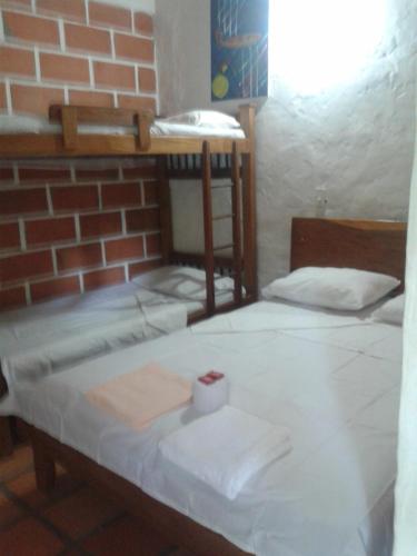 a room with two bunk beds and a brick wall at Selvablanca Hostel in San Jerónimo