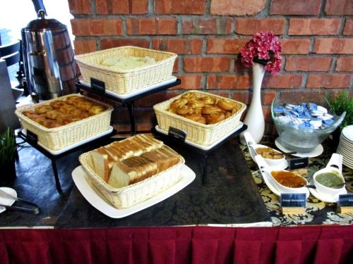 a table topped with baskets of bread and pastries at Ascott Sentral Kuala Lumpur in Kuala Lumpur