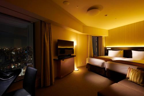 a hotel room with two beds and a television at Richmond Hotel Premier Asakusa International in Tokyo