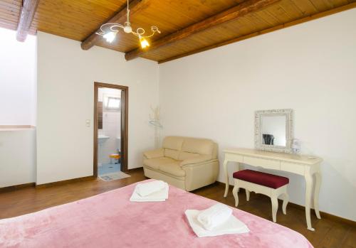 a bedroom with a bed and a chair and a desk at Zaros in Zarós