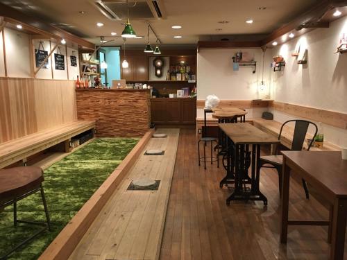a restaurant with tables and chairs and a green rug at MACCHI（マッチ） in Imabari