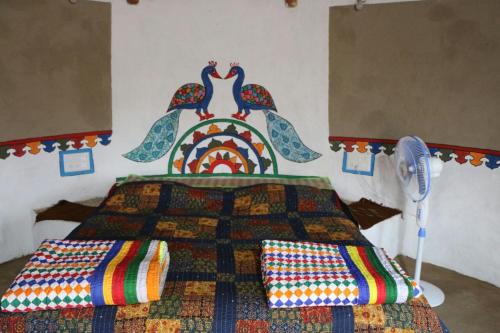 a bedroom with a bed with a quilt on it at Banni Village Resort - Rann Of Kutch in Bherandiāla