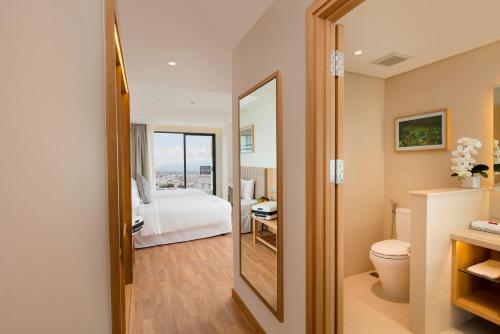 a bathroom with a bed and a mirror at Nagar Hotel Nha Trang in Nha Trang