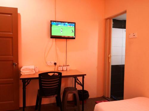 a room with a table with a tv on the wall at StarVilla Kinta River Front Medan Istana in Ipoh