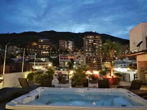 a hot tub on the roof of a building at night at Aqua Granada Hotel in Cali