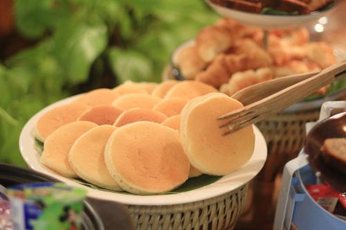 a plate of food with buns on a table at Cmor by Recall Hotels SHA Extra Plus in Chiang Mai