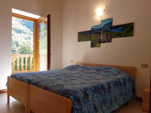 a bedroom with a bed and a large window at Villa Paradiso Parolari in Tenno