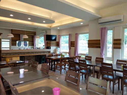 a dining room with tables and chairs and windows at DooDoo B&B in Jiji