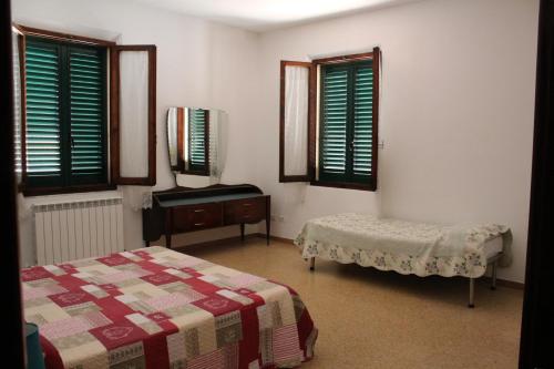 a bedroom with a bed and a table and windows at Via Roma 44 in Follonica