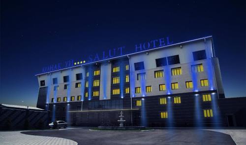 a hotel with a blue sign on top of it at Salut Hotel Almaty in Almaty