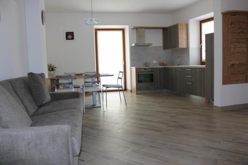 a living room with a couch and a table and a kitchen at Appartamento Morettina con terrazzo in Levico Terme