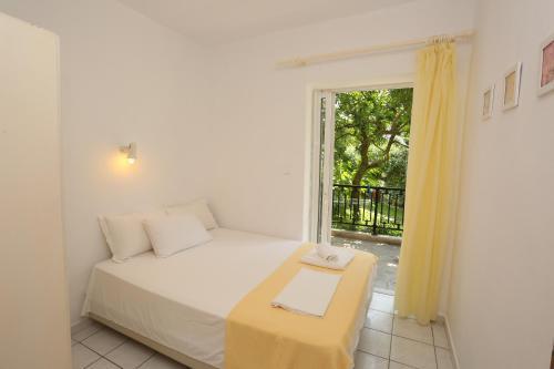 a small bedroom with a bed and a window at Iris Seafront Apartments in Fourka