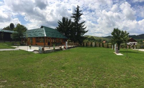 a building with a green roof in a field at Apartments&Camping ZIP in Kremna