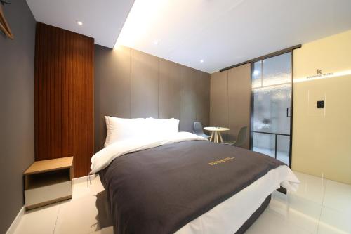 a bedroom with a large bed and a window at Hotel K in Jeonju