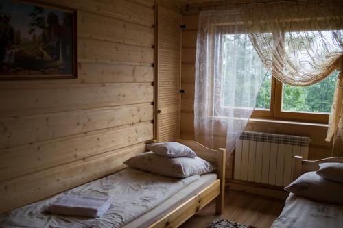 コシチェリスコにあるBacowa Chataのベッドルーム(ベッド1台、窓付)