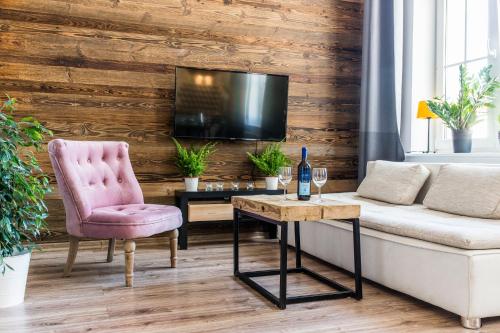 a living room with a couch and a chair and a tv at Way2Stay Apartment with parking in Toruń