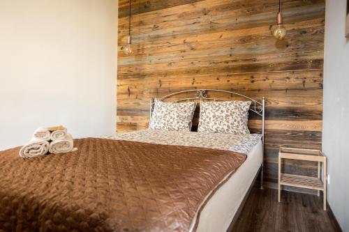 - une chambre avec un lit et un mur en bois dans l'établissement Way2Stay Apartment, à Toruń