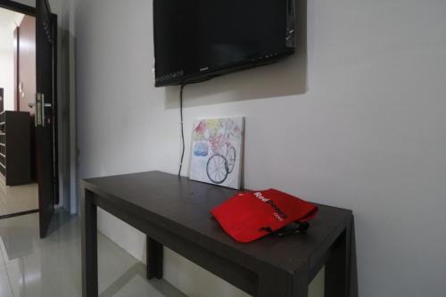 a black table with a television on a wall at RedDoorz @ Jalan Krakatau Medan in Medan