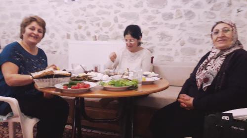 three women sitting around a table with a plate of food at Çamlıca Konak Çarsı in Safranbolu