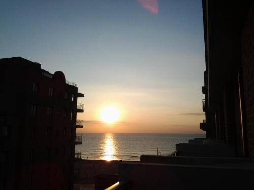 a sunset over the ocean from a building at Zonnig Appartement met Zeezicht in Koksijde