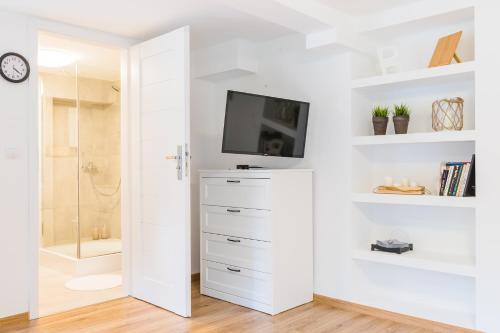 a white bathroom with a tv on a wall at Apartament Salmopolska5 in Szczyrk
