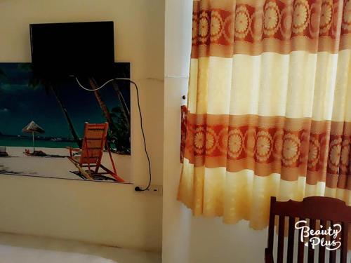 a room with a curtain and a television and a window at Khách sạn Duy Hoàng in Buon Ma Thuot