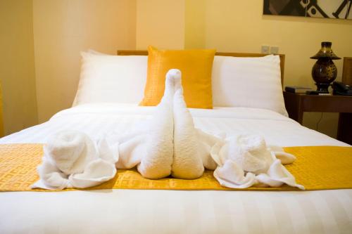 two towel animals are sitting on a bed at Royal Mansion Hotel in Tabaco