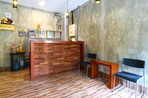 a waiting room with two chairs and a wall at Gempita House Bali in Legian