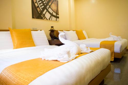 a room with three beds with white birds on them at Royal Mansion Hotel in Tabaco