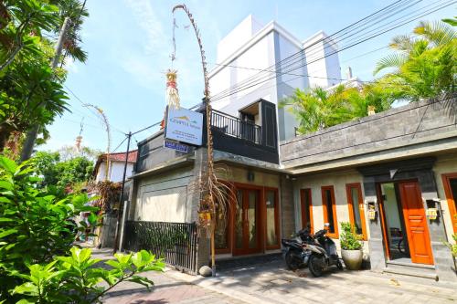 a building with a motorcycle parked in front of it at Gempita House Bali in Legian